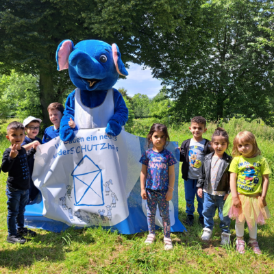 Kinderschutzhaus: Kinder mit Maskottchen